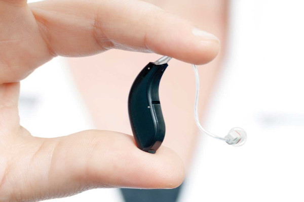 Specialist holding up a hearing aid