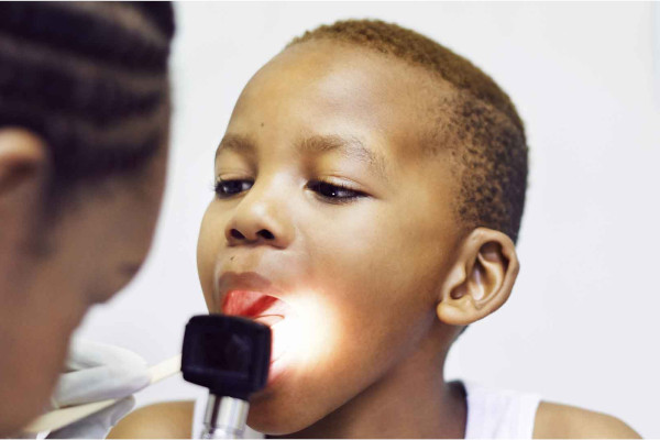 Young boy getting his mouth checked by an ENT specialist
