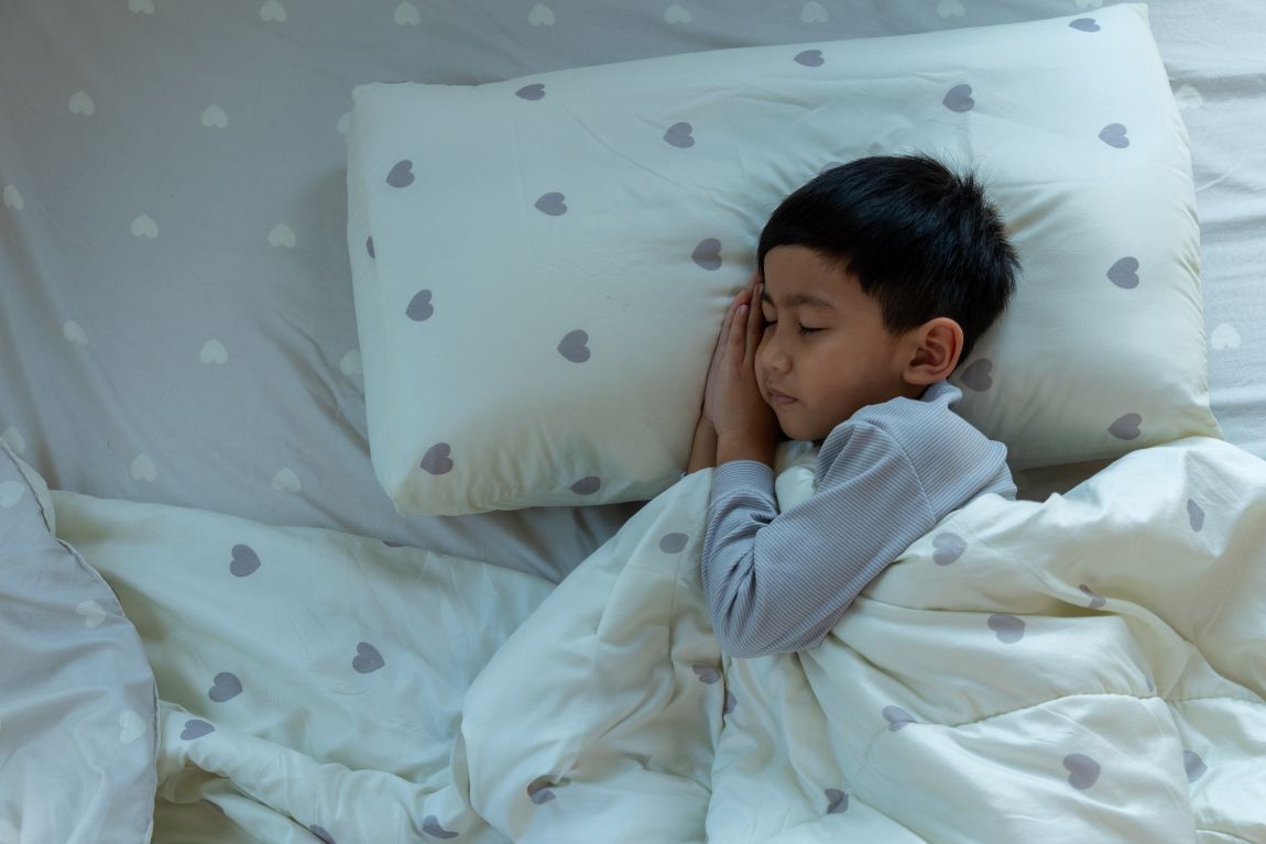 child sleeping on bed